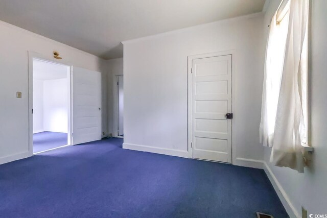 unfurnished room featuring dark colored carpet