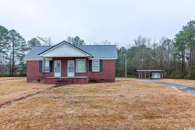 view of front of house featuring a carport and a front lawn