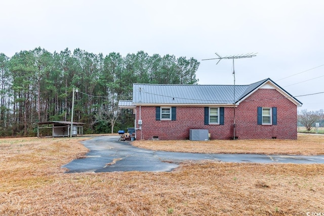 view of property exterior with central AC and a yard