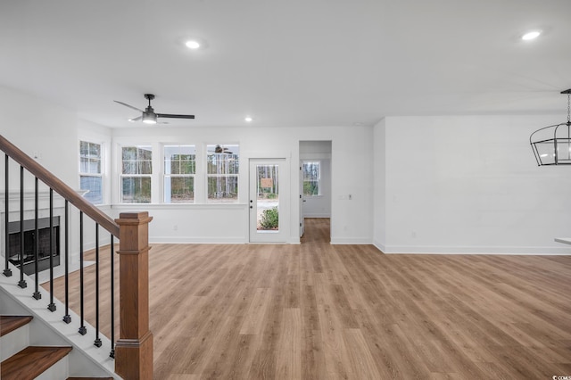 unfurnished living room featuring ceiling fan and light hardwood / wood-style flooring