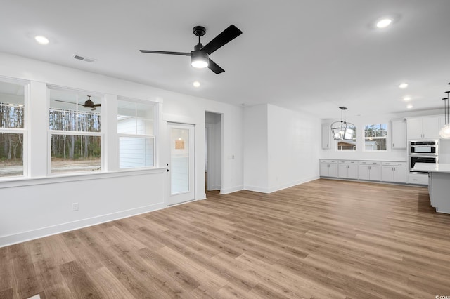 unfurnished living room with ceiling fan and light hardwood / wood-style flooring