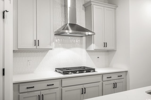 kitchen featuring stainless steel gas stovetop, tasteful backsplash, and wall chimney range hood