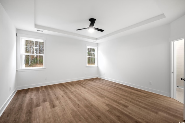 spare room featuring hardwood / wood-style flooring and a tray ceiling