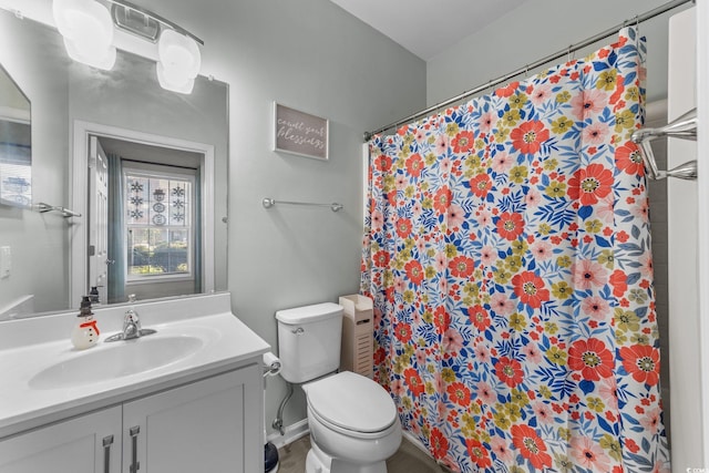 bathroom featuring a shower with shower curtain, vanity, toilet, and a healthy amount of sunlight