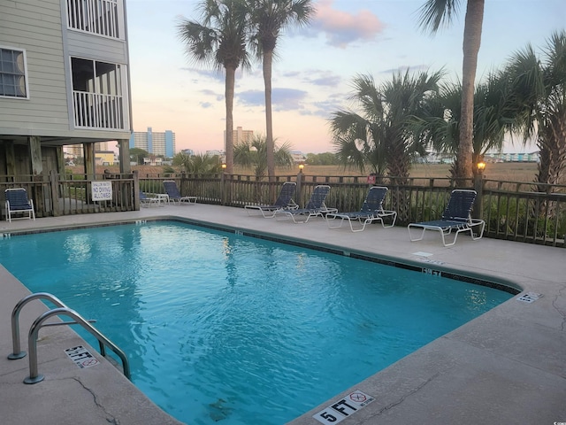 pool at dusk with a patio