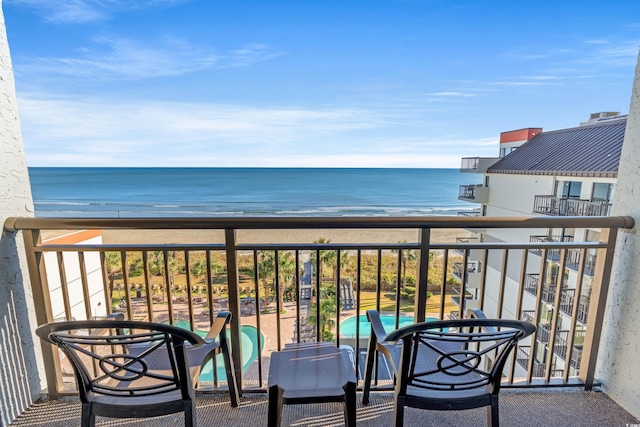 balcony featuring a beach view and a water view