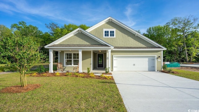 craftsman-style home featuring a front lawn, covered porch, and a garage