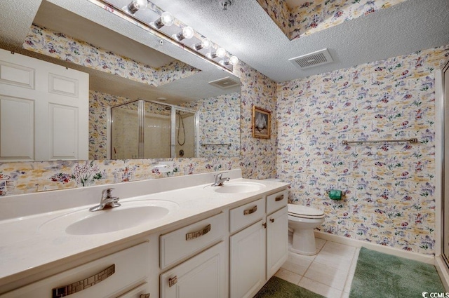 bathroom with tile patterned floors, vanity, a textured ceiling, and walk in shower