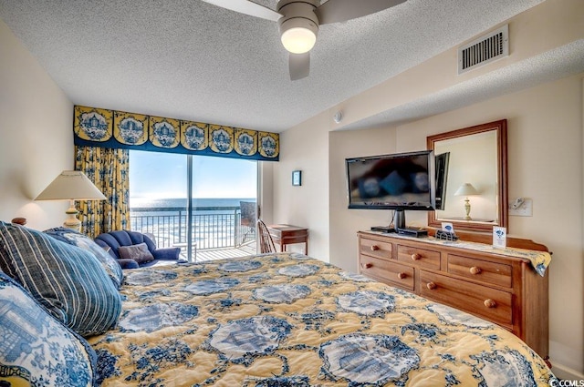 bedroom featuring a textured ceiling, access to outside, and ceiling fan