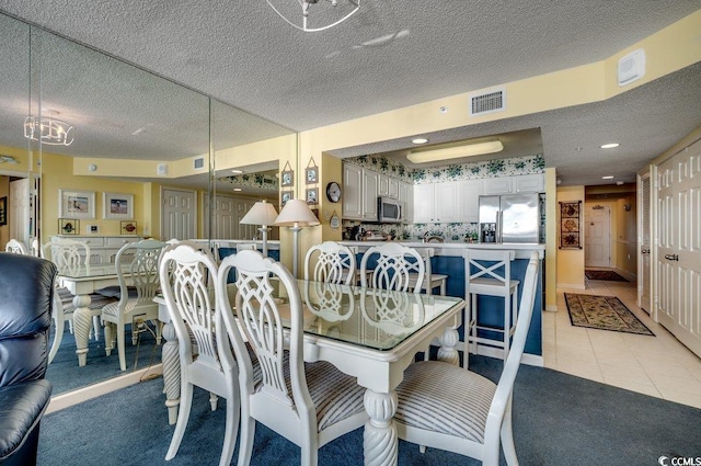 dining space with light tile patterned floors and a textured ceiling