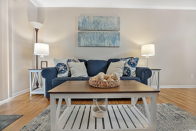 living area with crown molding and hardwood / wood-style floors