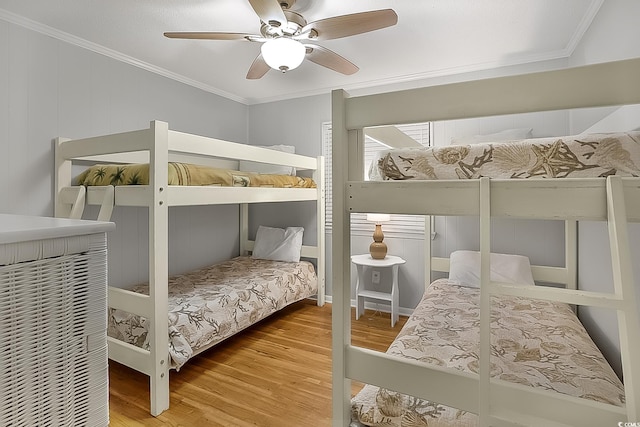 bedroom featuring hardwood / wood-style floors, ceiling fan, and crown molding