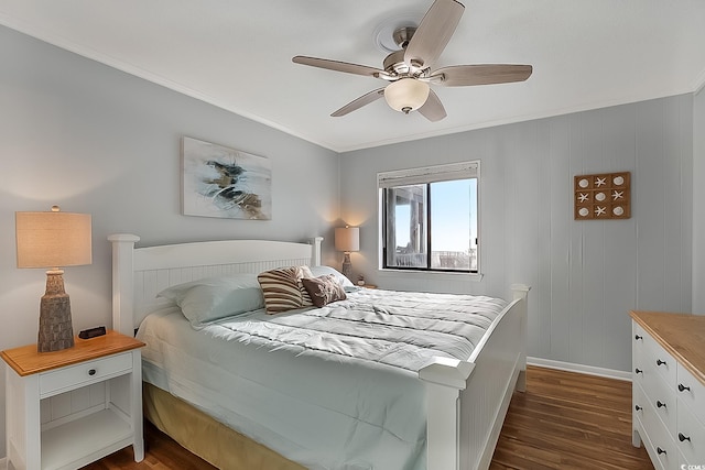 bedroom with wooden walls, crown molding, ceiling fan, and dark wood-type flooring