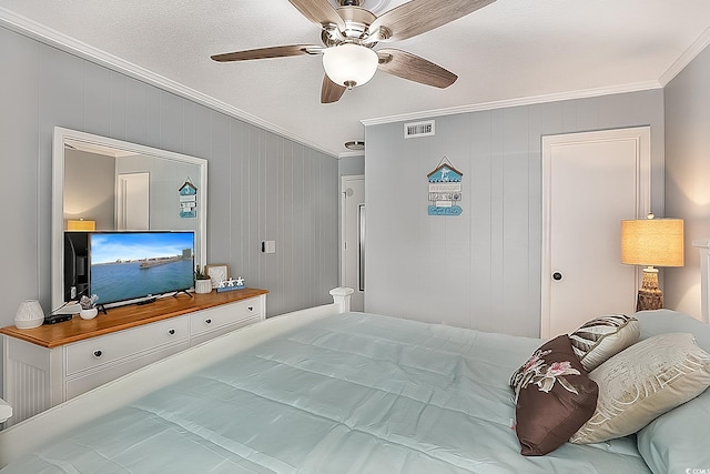 bedroom featuring a textured ceiling, wooden walls, ceiling fan, and ornamental molding