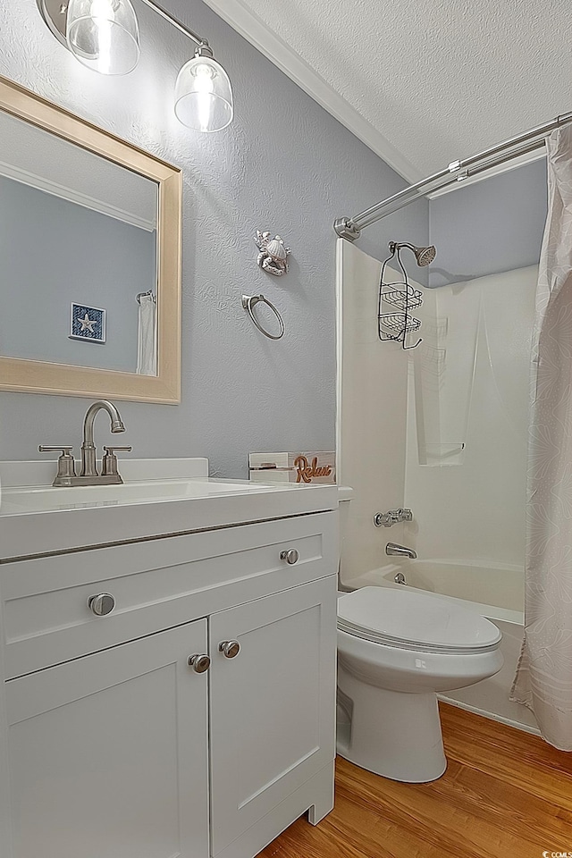 full bathroom with hardwood / wood-style floors, vanity, toilet, shower / bathtub combination with curtain, and a textured ceiling