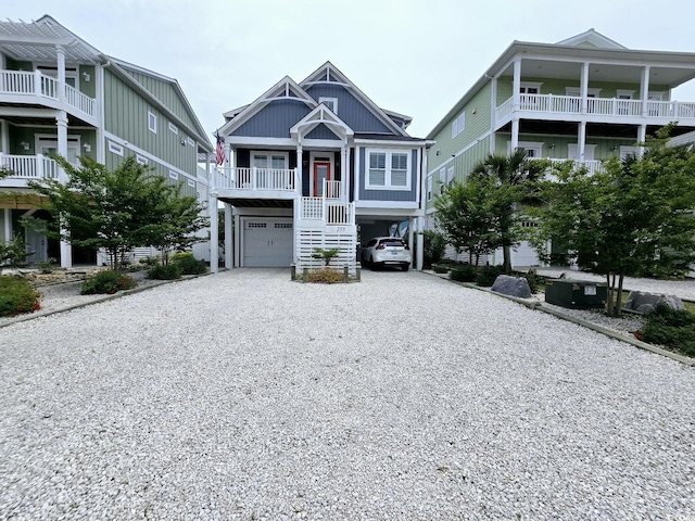 coastal inspired home featuring stairway, driveway, a porch, and a carport