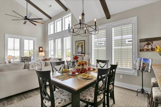 dining room with beamed ceiling, wood finished floors, visible vents, and ceiling fan with notable chandelier