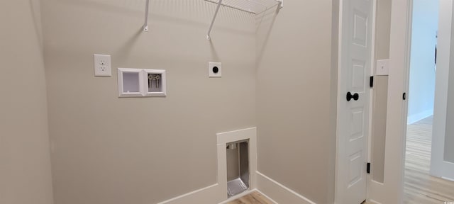 laundry area featuring electric dryer hookup and light hardwood / wood-style flooring