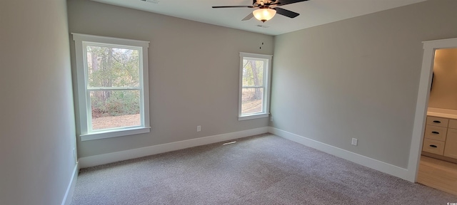 unfurnished bedroom with ceiling fan, light colored carpet, and multiple windows