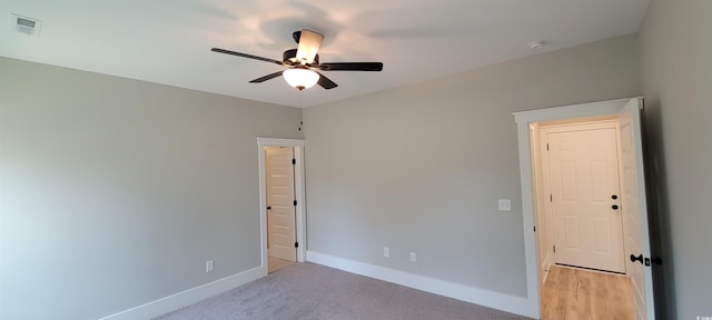 spare room with ceiling fan and light carpet