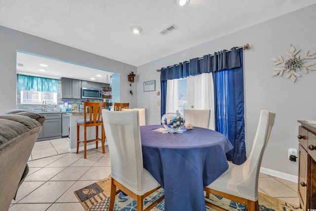 tiled dining room featuring sink