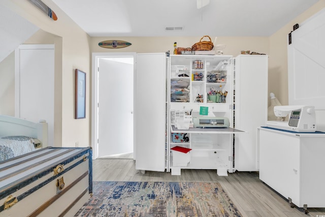 kitchen featuring white cabinets, a barn door, and light hardwood / wood-style floors