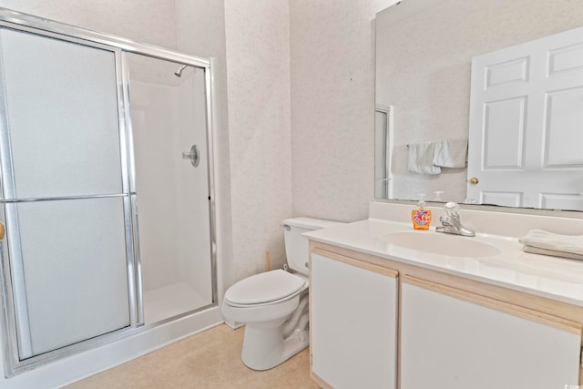 bathroom featuring vanity, toilet, and a shower with door