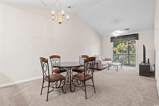 dining area featuring light colored carpet, vaulted ceiling, and an inviting chandelier