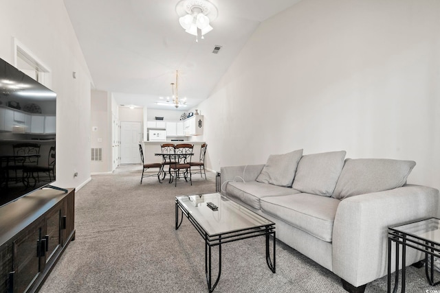 carpeted living room featuring ceiling fan with notable chandelier and lofted ceiling