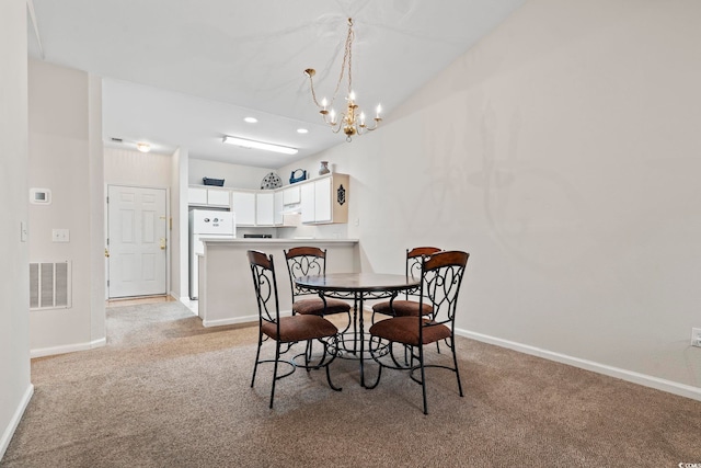 carpeted dining area featuring an inviting chandelier