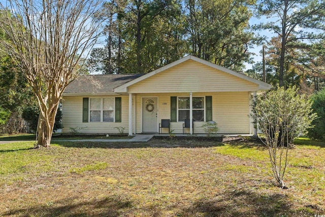 single story home with covered porch and a front yard