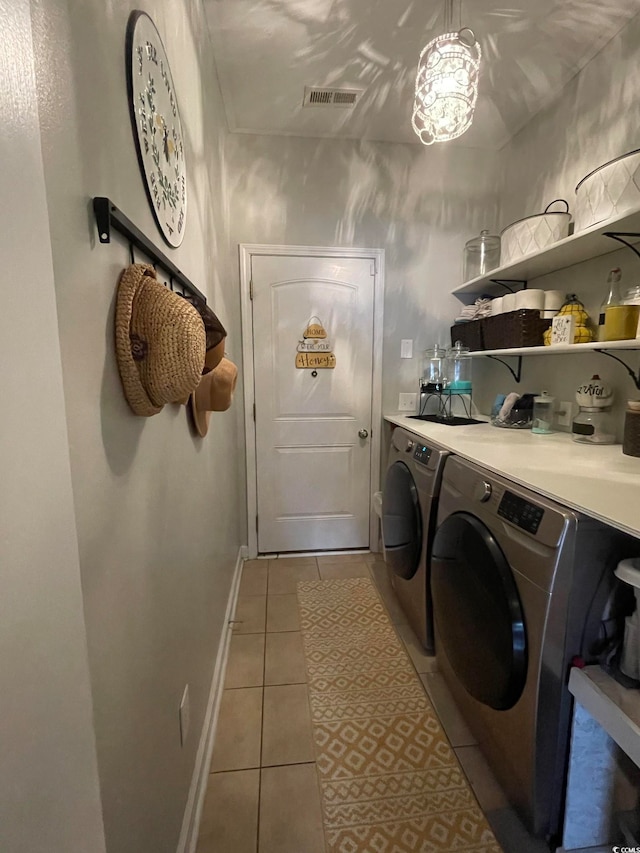 clothes washing area featuring separate washer and dryer and light tile patterned floors