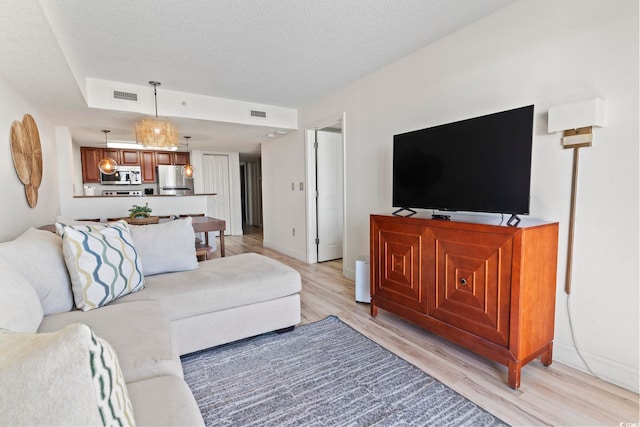 living room featuring a textured ceiling and light wood-type flooring