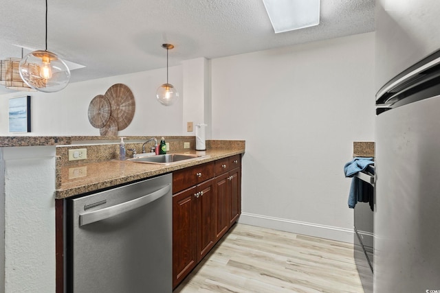 kitchen with dishwasher, light hardwood / wood-style floors, hanging light fixtures, and sink