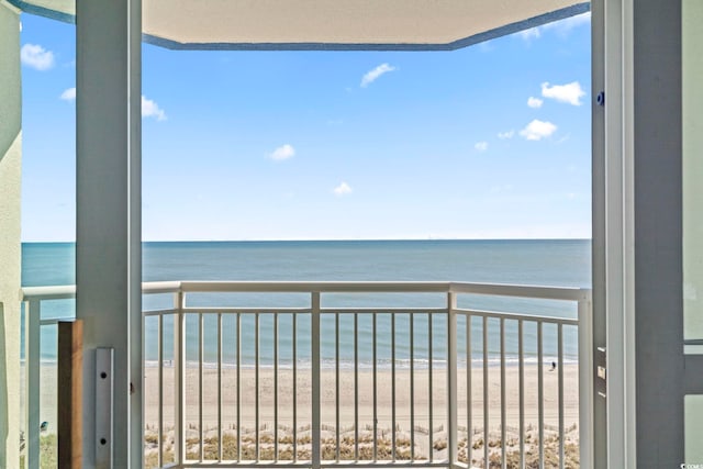 balcony featuring a view of the beach and a water view