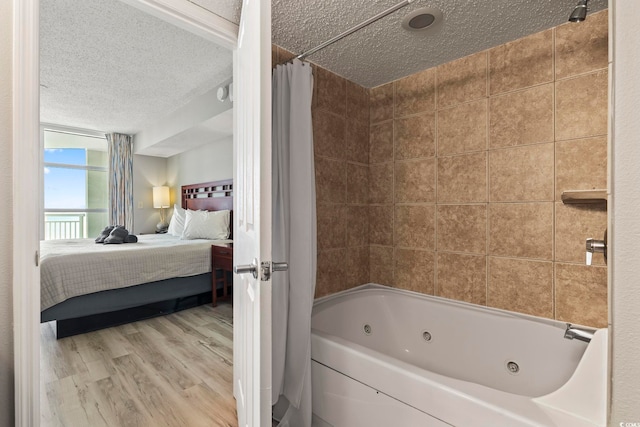 bathroom featuring hardwood / wood-style floors, shower / bath combo with shower curtain, and a textured ceiling