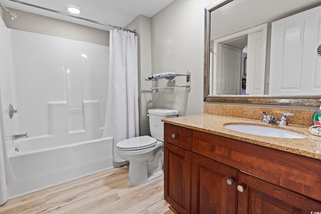 full bathroom featuring shower / bath combo with shower curtain, hardwood / wood-style floors, vanity, and toilet