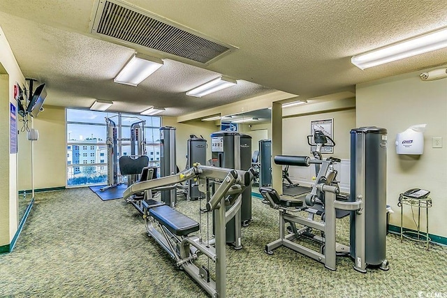 exercise room featuring carpet flooring and a textured ceiling