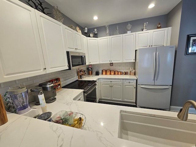 kitchen featuring white cabinets, appliances with stainless steel finishes, and light stone countertops