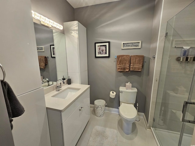 bathroom featuring tile patterned flooring, vanity, a shower with shower door, and toilet