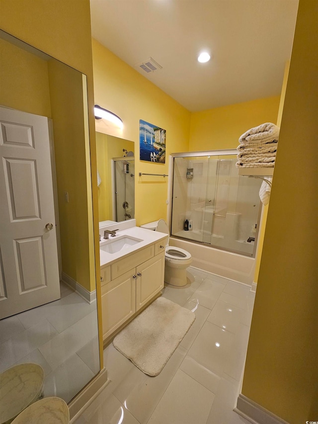 full bathroom with tile patterned floors, vanity, toilet, and bath / shower combo with glass door