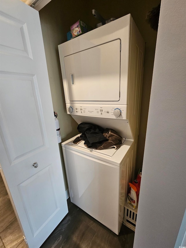 laundry area featuring dark hardwood / wood-style flooring and stacked washing maching and dryer