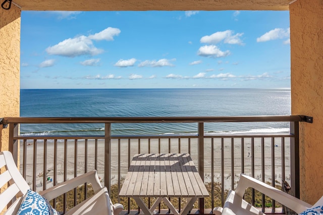 balcony with a beach view and a water view