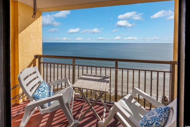 balcony featuring a view of the beach and a water view