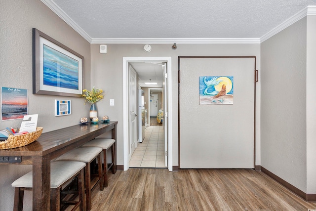 interior space with hardwood / wood-style floors, a textured ceiling, and ornamental molding