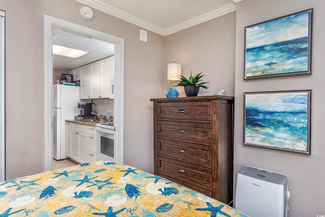 tiled bedroom with white fridge, sink, crown molding, and ensuite bath