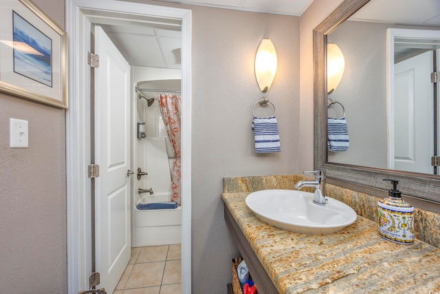 bathroom featuring tile patterned floors, shower / bath combo with shower curtain, and vanity