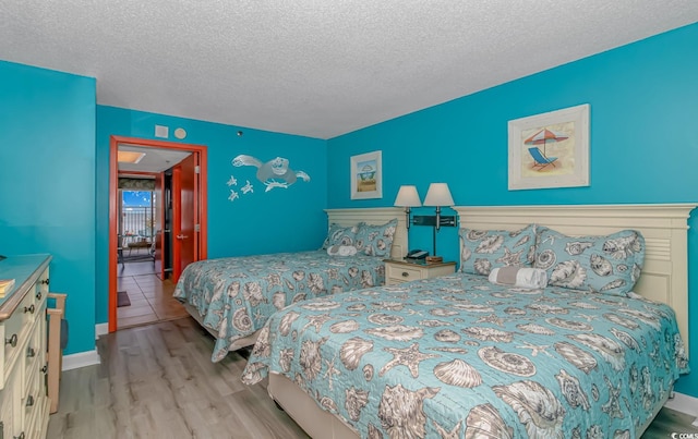 bedroom with a textured ceiling and light wood-type flooring