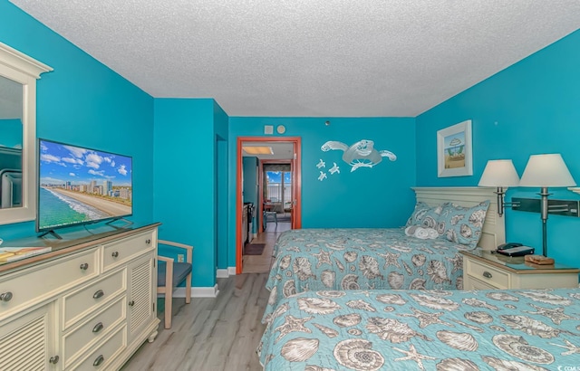 bedroom with light hardwood / wood-style floors and a textured ceiling