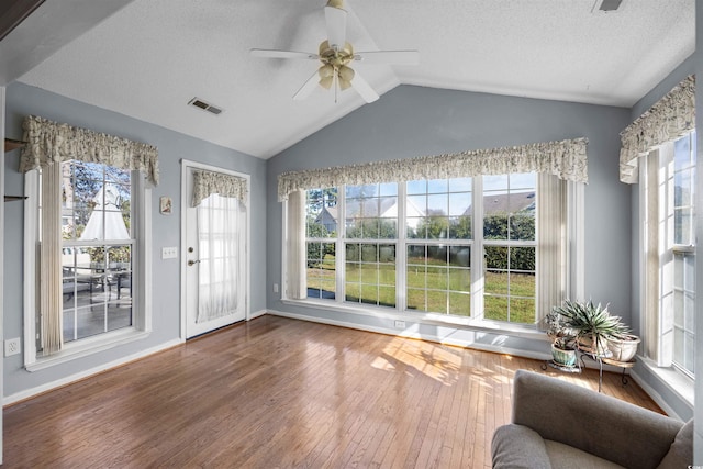 interior space with hardwood / wood-style floors, a healthy amount of sunlight, and lofted ceiling